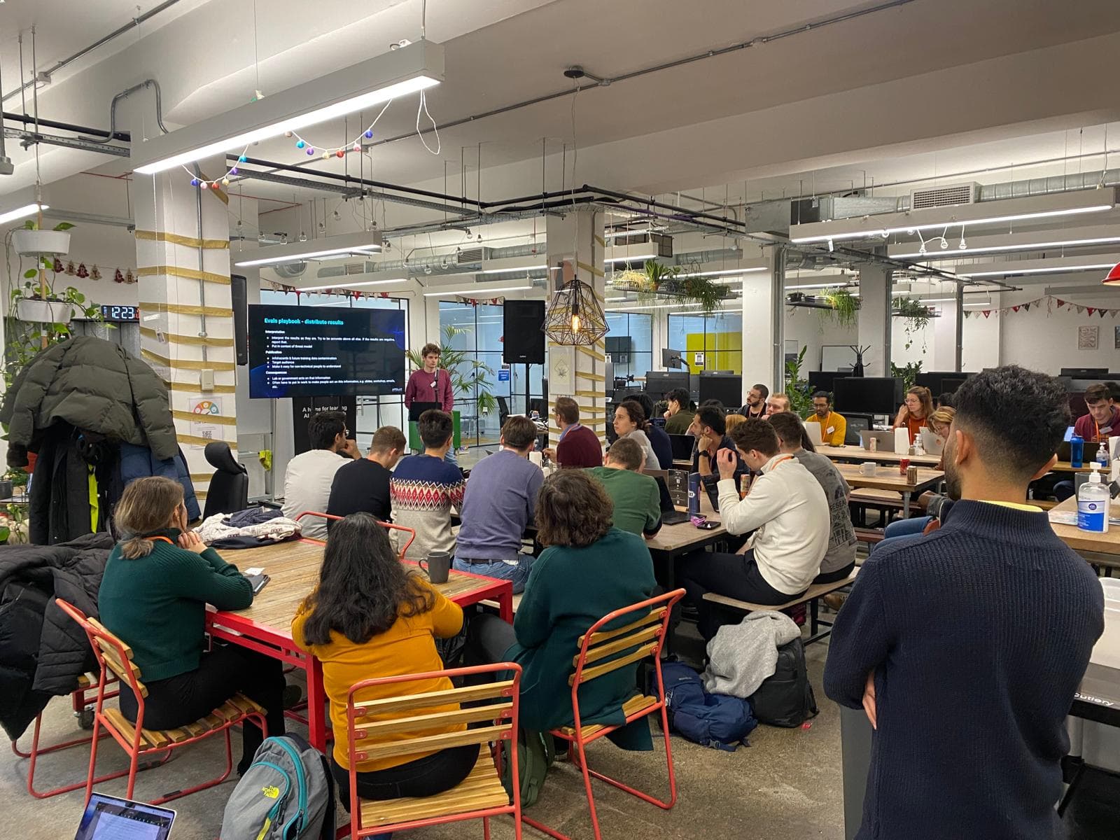 Attendees at the AI evals hackathon watching a presentation